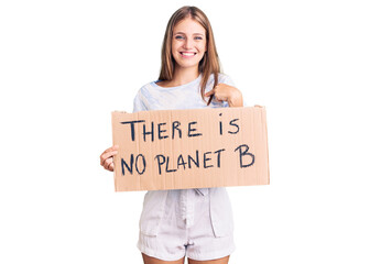 Young beautiful blonde woman holding there is no planet b banner pointing finger to one self smiling happy and proud