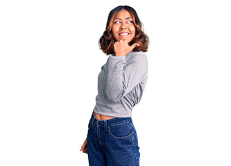 Young beautiful mixed race woman wearing casual clothes smiling with happy face looking and pointing to the side with thumb up.