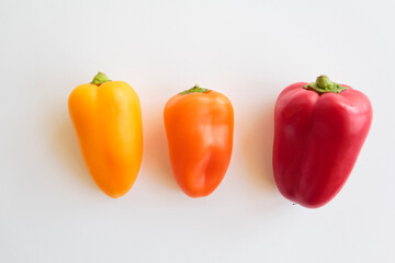 Top view of Red pepper, orange pepper and yellow pepper on white background
