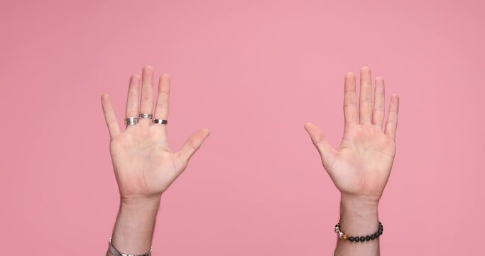 two hands gesturing hey you, give five on pink background