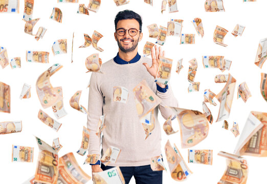 Young handsome hispanic man wearing elegant clothes and glasses showing and pointing up with fingers number five while smiling confident and happy.