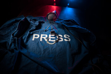 Freedom of the press and journalism concept. Blue journalist (press) vest in dark with backlight...