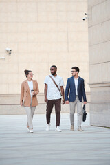 Three young intercultural managers chatting about their plans for the evening