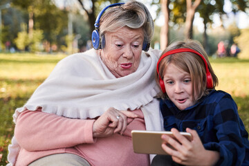 Granny and kid looking at the phone with real emotions