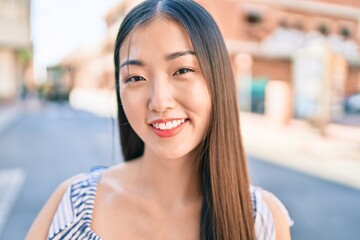 Young chinese woman smiling happy walking at street of city.