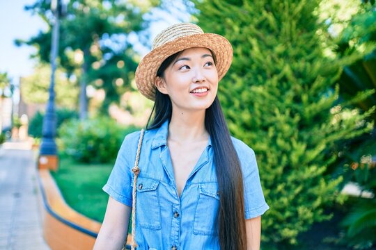 Young chinese tourist woman smiling happy walking at the park.