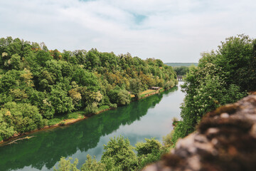 Fototapeta na wymiar Fascinating Korana river coloured in green as the dense forest in its surroundings, beautiful tourist destination near the city of Karlovac, Croatia