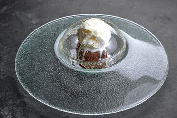 Chocolate fondant with ice cream, on a transparent plate, on a black background