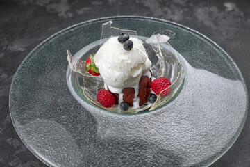 Chocolate fondant with ice cream, on a transparent plate, on a black background