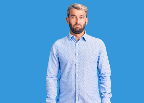 Young handsome blond man wearing elegant shirt depressed and worry for distress, crying angry and afraid. sad expression.