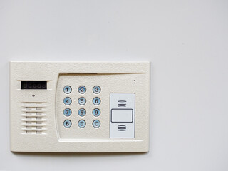 White metal intercom on a white wall. Object in the corner of the frame