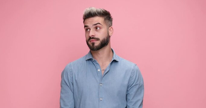 casual attractive man looking around, feeling clueless then excited because of the great ideea that struk him against pink background