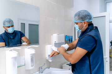 Obraz premium Surgeon is washing hands. Doctor washes hands. Hands disinfection before surgery. Closeup.