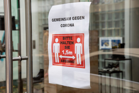 German sign in store window to keep distance because of corona virus