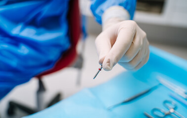 Fototapeta premium Dental prosthesis, artificial tooth. Dentist`s hands working on the denture. False teeth.