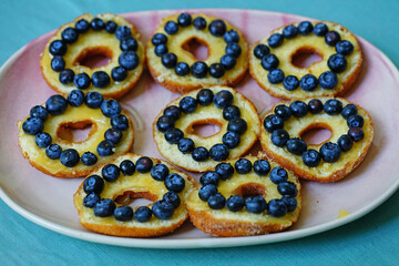 Platter of donuts cut in half with lemon curd and fresh blueberries