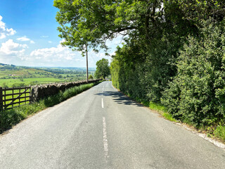 Looking along, Skipton Road, with dry stone walls, fields and trees near, Bradley, Skipton, UK