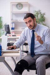 Young leg injured employee working in the office