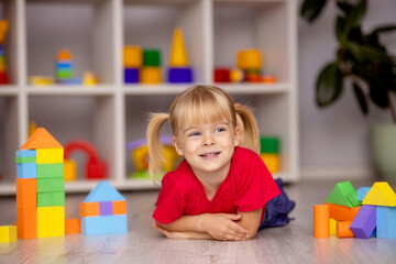 The girl plays with toys at home, in kindergarten or nursery. Child development.