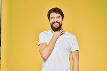 Man gesturing with hands emotions lifestyle white t-shirt yellow isolated background