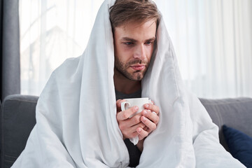 Man sitting under blanket