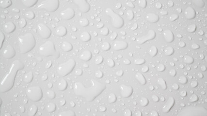 Clear water drops on a white surface
