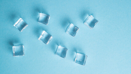 Acrylic ice cubes for photography on blue background. Transparent squares. Acrylic pieces. Crystal clear ice cubes