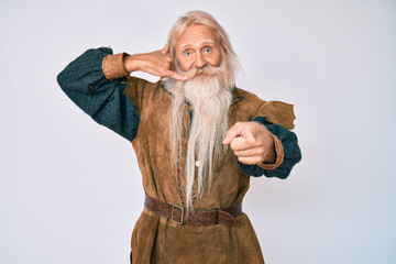 Old senior man with grey hair and long beard wearing viking traditional costume smiling doing...
