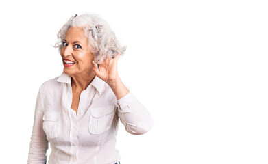 Senior grey-haired woman wearing casual clothes smiling with hand over ear listening an hearing to...