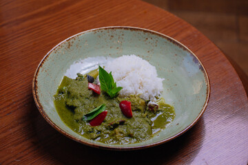 Thai food Vegetable green curry with white rice on old wooden background.