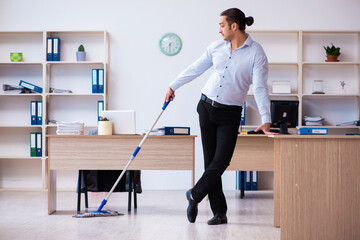 Young male employee cleaning office during pandemic