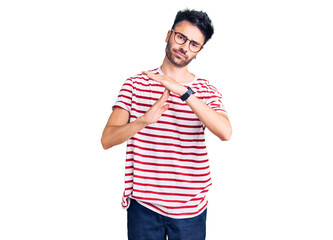 Fototapeta premium Young hispanic man wearing casual clothes doing time out gesture with hands, frustrated and serious face