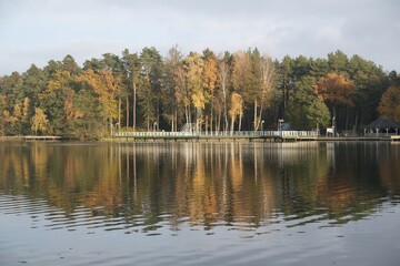 Pier and holiday resort on the lake by the forest in beautiful autumn scenery. Lapino Lake, Kashubia, Poland
