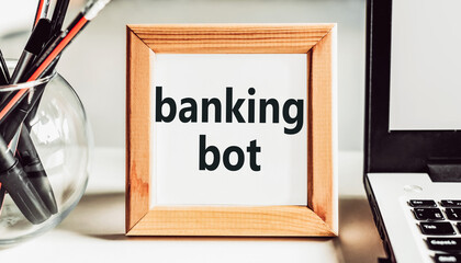 Banking bot text in a wooden frame on the office table. The term refers to an application that performs automated banking tasks over the Internet.