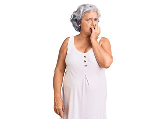 Senior woman with gray hair wearing casual clothes looking stressed and nervous with hands on mouth biting nails. anxiety problem.
