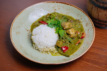 Thai Chicken green curry with eggplant, sweet basil and hot chili famous traditional Thai food with white rice.