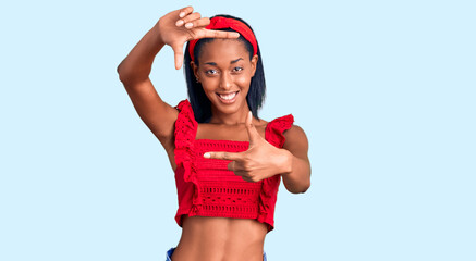 Young african american woman wearing casual summer clothes smiling making frame with hands and fingers with happy face. creativity and photography concept.