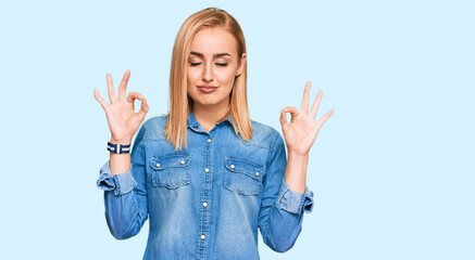 Beautiful caucasian woman wearing casual denim jacket relax and smiling with eyes closed doing meditation gesture with fingers. yoga concept.