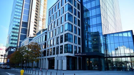 Fototapeta premium Blue curtain wall made of toned glass and steel constructions under blue sky. A fragment of a building.