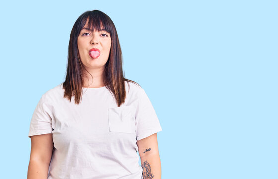 Young plus size woman wearing casual clothes sticking tongue out happy with funny expression. emotion concept.