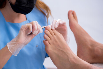Podiatrist treating feet during procedure