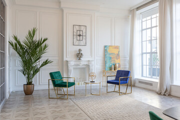 modern and very stylish interior design of large studio apartment with fashionable furniture with gold elements. very light and bright room with big windows