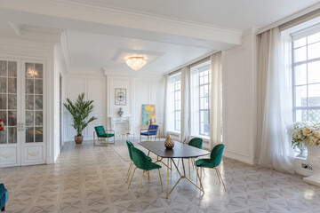 modern and very stylish interior design of large studio apartment with fashionable furniture with gold elements. very light and bright room with big windows