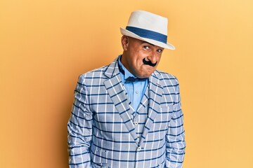 Mature middle east man with mustache wearing vintage and elegant fashion style smiling looking to the side and staring away thinking.