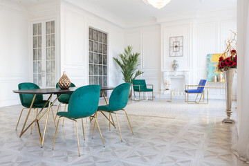 modern and very stylish interior design of large studio apartment with fashionable furniture with gold elements. very light and bright room with big windows