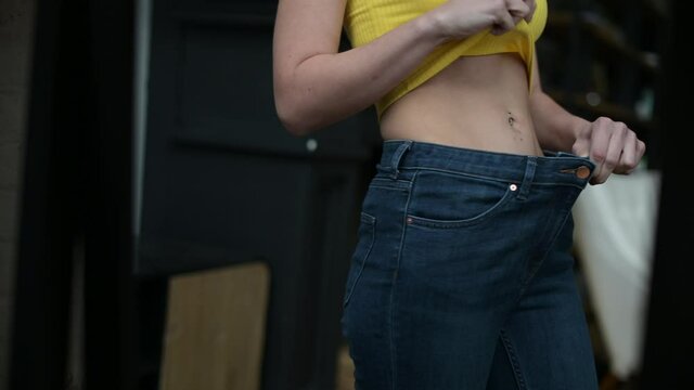 Jeans fit loosely on a thinner woman who is very complex and has problems with anorexia