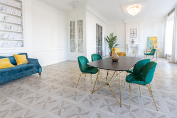 modern and very stylish interior design of large studio apartment with fashionable furniture with gold elements. very light and bright room with big windows