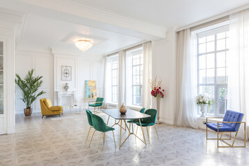 modern and very stylish interior design of large studio apartment with fashionable furniture with gold elements. very light and bright room with big windows