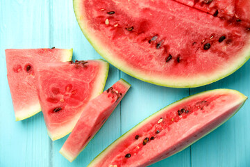 Tasty ripe cut watermelon on light blue wooden table, flat lay