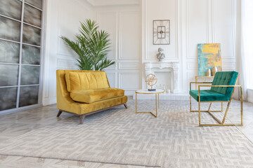 modern and very stylish interior design of large studio apartment with fashionable furniture with gold elements. very light and bright room with big windows